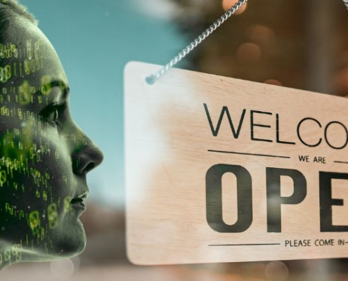 woman's face with technology code behind her facing a "welcome, we're open" sign hanging in a store front window