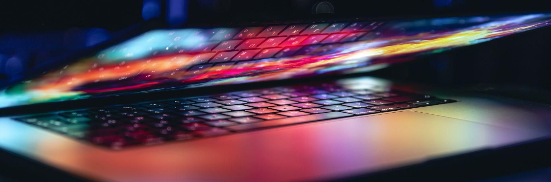 a laptop partially open with vibrant lights coming from the screen
